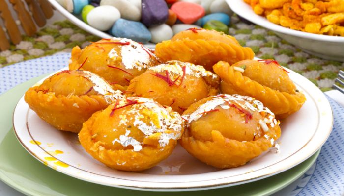 Chandrakala, a traditional Indian sweet pastry filled with khoya and nuts, served on a plate