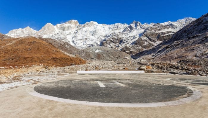 A helipad near Kedarnath Dham, surrounded by mountainous terrain and lush greenery