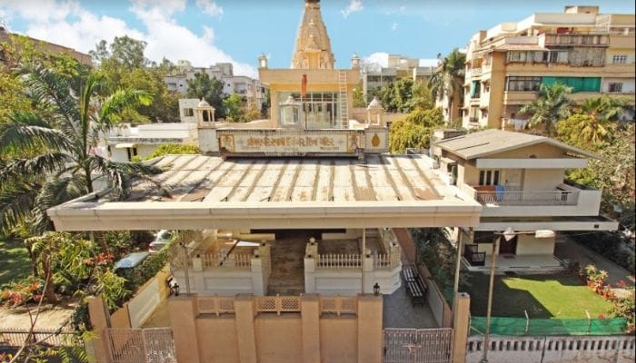 A serene view of the Shri Mahavir Swami Jain Temple in Ahmedabad, highlighting its peaceful surroundings and elegant design.